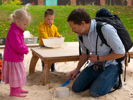 Photographer Danny Burrows with children in sandpit